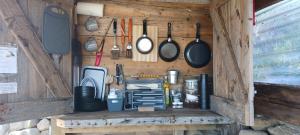 una parete in legno con pentole, padelle e utensili di Fairy Cove at Rosemount Glamping a Carlingford