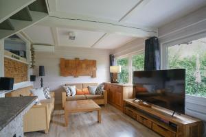 a living room with a large flat screen tv at Ferienhaus "Gestiefelter Kater" am See im Bergland in Kirchheim