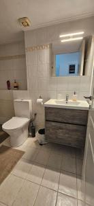 a bathroom with a toilet and a sink at Eva's Apartment in Lamía +13 photos
