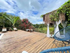 a wooden deck with chairs and umbrellas at Trancoso Villa Nobre in Trancoso