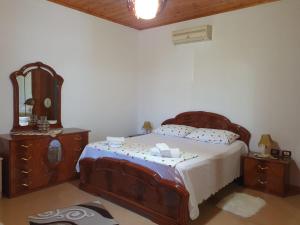 a bedroom with a large bed with a mirror at Sara Guesthouse in Berat