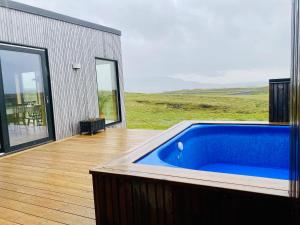 Beautiful cottage with Mountain View في فلودير: حوض استحمام أزرق كبير موجود على سطح السفينة بجوار مبنى