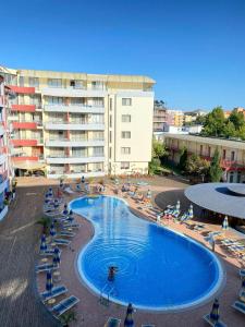 a large swimming pool with lounge chairs and a hotel at Central Plaza Apartment in Sunny Beach