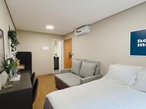 a hotel room with a bed and a couch at Apê Paulista Augusta in São Paulo