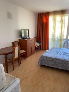 a bedroom with a bed and a desk and a table at Central Plaza Apartment in Sunny Beach