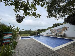 a swimming pool with a wooden deck next to a building at Trancoso Villa Nobre in Trancoso +35 photos