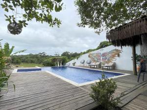 a resort with a swimming pool and a wooden deck at Trancoso Villa Nobre in Trancoso