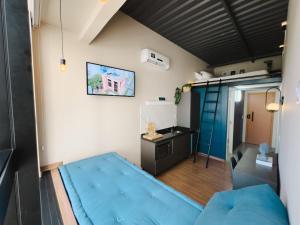 a small room with a blue couch and a desk at Apê Paulista Augusta in São Paulo