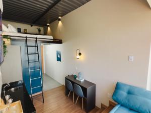 a room with a couch and a desk and a bunk bed at Apê Paulista Augusta in São Paulo