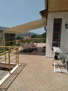 a patio with a table and a bench on a roof at Sara Guesthouse in Berat