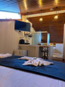a large bed in a room with a kitchen at Lofts do Pilar - pousada in Ouro Preto