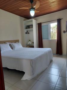 a bedroom with a bed with a ceiling fan and a window at Pousada Vegas in São Roque +169 photos