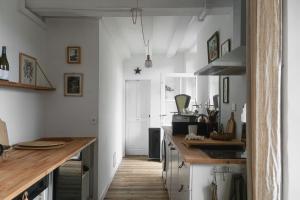 a kitchen with white walls and a wooden counter top at Maison d'hôtes La bien-Aimée in Montrevault