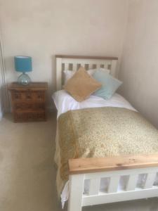 a bedroom with a bed and a table with a lamp at Avalon cottage in Glastonbury +5 photos