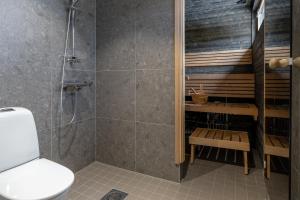 a bathroom with a shower and a toilet at Villa Kuusi by HiYlläs in Äkäslompolo +15 photos