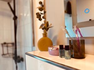 a counter top with cosmetics and a vase on it at FeWo Niederberg - moderner Style trifft gemütliche Natürlichkeit in Neukirchen-Vluyn +15 photos