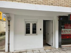 a white building with a door and a window at Estudio en Santander in Santander