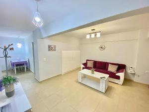 a living room with a red couch and a table at La Petite Maison Nicole in Thessaloniki