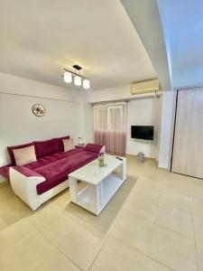 a living room with a red couch and a table at La Petite Maison Nicole in Thessaloniki