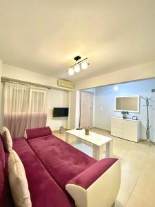 a living room with a red couch and a table at La Petite Maison Nicole in Thessaloniki