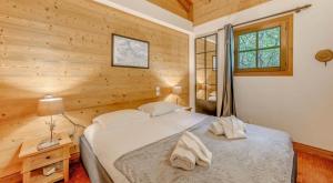 a bedroom with a bed in a room with wooden walls at Résidence Blue Wood - Appartement en chalet 8 personnes 4, séjour enfamille ou entre amis MAE-0701 in Tignes