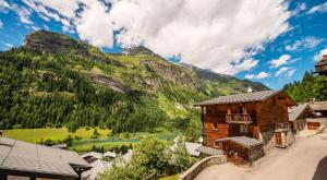 a wooden building with a mountain in the background at Résidence Blue Wood - Appartement en chalet 8 personnes 4, séjour enfamille ou entre amis MAE-0701 in Tignes