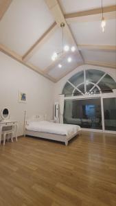 a bedroom with a bed and a desk in a room at Jennyville Pension in Seogwipo