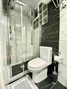 a black and white bathroom with a toilet and a shower at La Petite Maison Nicole in Thessaloniki +15 photos