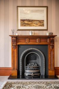 a fireplace in a living room with a painting above it at The Old Bank House Self Catering Apartment Dornoch in Dornoch