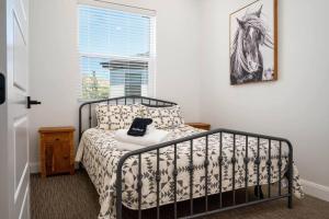 a bedroom with a bed with a black and white bedspread at Villages Alpine Escape in Eden