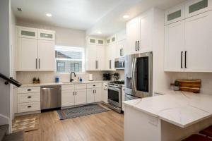 a large white kitchen with white cabinets and stainless steel appliances at Villages Alpine Escape in Eden