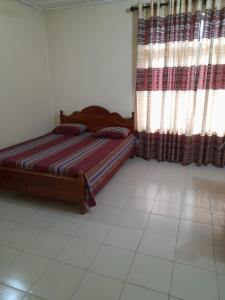 a bedroom with a bed and a window with curtains at Seven Star Guest Inn in Passara +2 photos