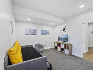a living room with a couch and a tv at Alpine Deer Hideaway in Eden