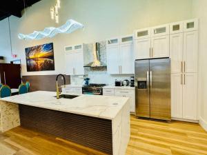 a kitchen with a stainless steel refrigerator and white cabinets at Downtown Dreaming Alex City Near Lake Martin in Alexander City