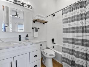 a bathroom with a sink toilet and a shower curtain at Alpine Deer Hideaway in Eden +21 photos