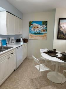 a kitchen with white cabinets and a table and chairs at Welcome to Camp Sycamore in Pittsburgh