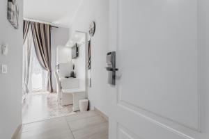 a white hallway with a mirror and a window at Vatican Sweet Guest House in Rome +34 photos