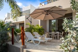 a patio with a table and chairs and an umbrella at Villa con piscina privada en coveñas sucre in Coveñas