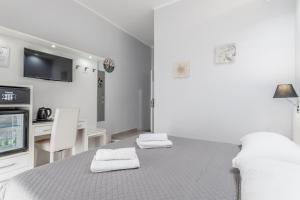 a white living room with a table and a tv at Vatican Sweet Guest House in Rome
