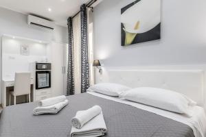 a white bedroom with a bed with towels on it at Vatican Sweet Guest House in Rome