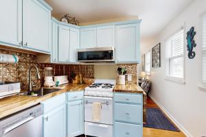 a kitchen with blue cabinets and white appliances at Town of Rehoboth Beach --- 37200 Burton Ave. in Rehoboth Beach +16 photos