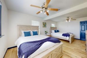a bedroom with two beds and a ceiling fan at The Baytown Getaway - Main House in Baytown +28 photos