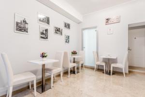 a dining room with white tables and white chairs at Vatican Sweet Guest House in Rome