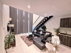a living room with a couch and a staircase at Gem of Embassy Gardens in Accra