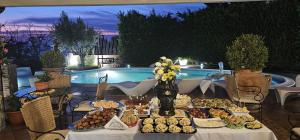 a table filled with food next to a pool at Villa Fontana Saia in Paola