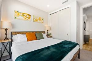 a bedroom with a large bed with orange and green pillows at Modern dntwn apt- prime location in Salt Lake City +29 photos