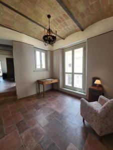 a living room with a couch and a table and windows at Magic Spell - 200 mq - zona centro - intera casa vacanze con ampi spazi relax, fino a 10 ospiti, ----------------- tassa soggiorno inclusa in Spello