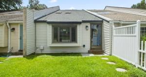 ein Haus mit einem weißen Zaun im Hof in der Unterkunft Cypress Cottage in Charleston