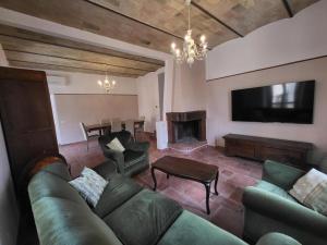 a living room with a couch and a television and a table at Magic Spell - 200 mq - zona centro - intera casa vacanze con ampi spazi relax, fino a 10 ospiti, ----------------- tassa soggiorno inclusa in Spello +20 photos