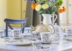 a table with a tea pot and cups and a vase with flowers at Nis-Puk in Norddorf +12 photos